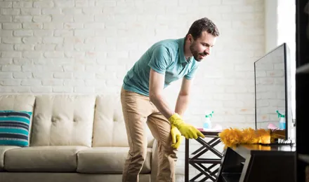 Man dusting his house with a duster
