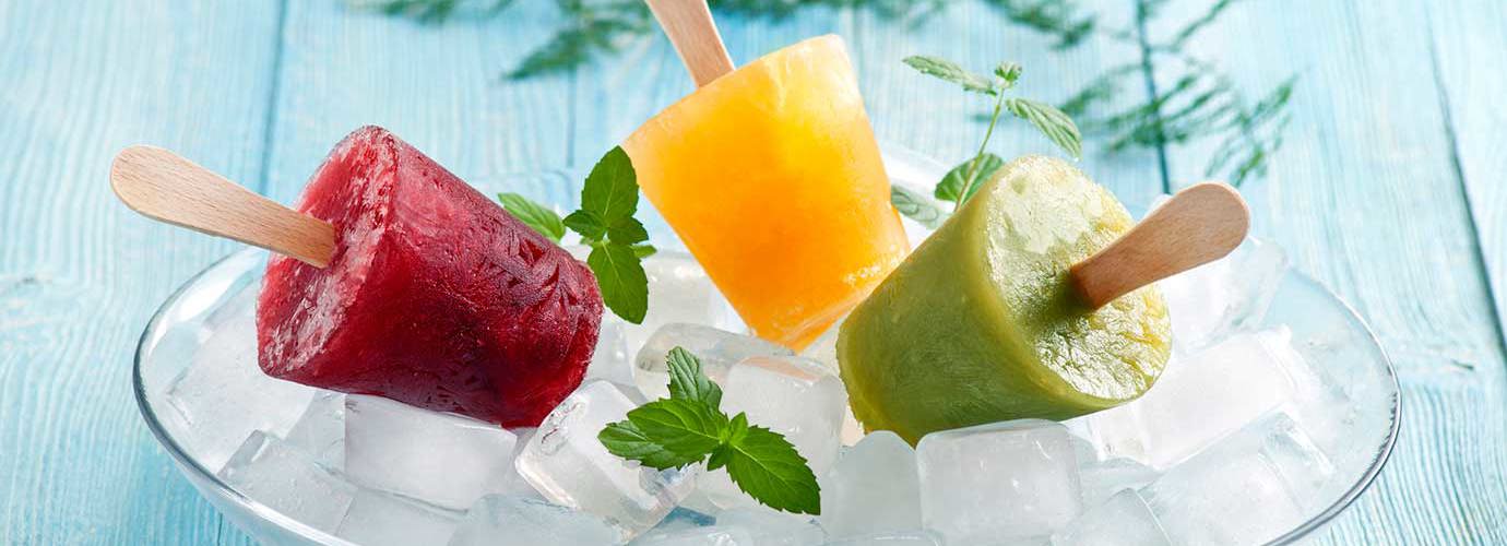 Drie fruitijsjes op een plek bedekt met ijsblokjes