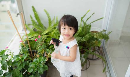 Little girl taking care of indoor plants